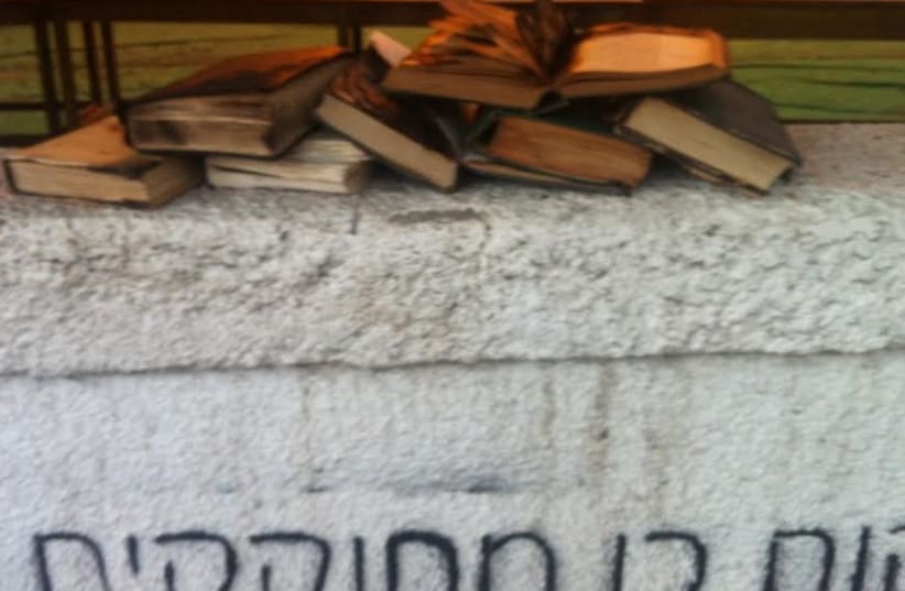 Burned books and graffiti at Tel Aviv synagogue (photo credit: POLICE SPOKESPERSON'S UNIT)