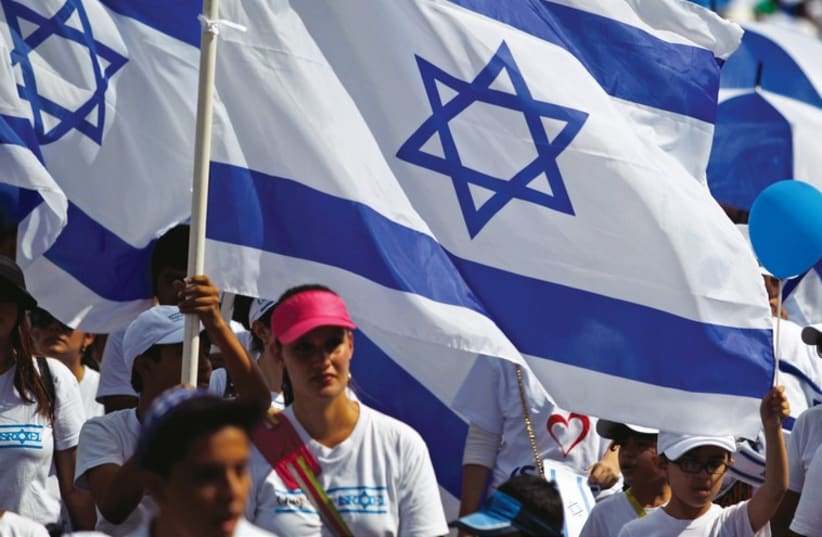 People carry Israeli flags during a Jerusalem Day march in the capital. (photo credit: REUTERS)