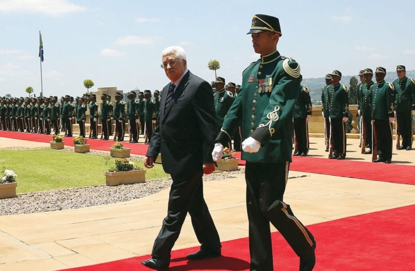 Palestinian Authority President Mahmoud Abbas walks away after inspecting an honor guard at the Union Building in Pretoria last week. (photo credit: REUTERS)