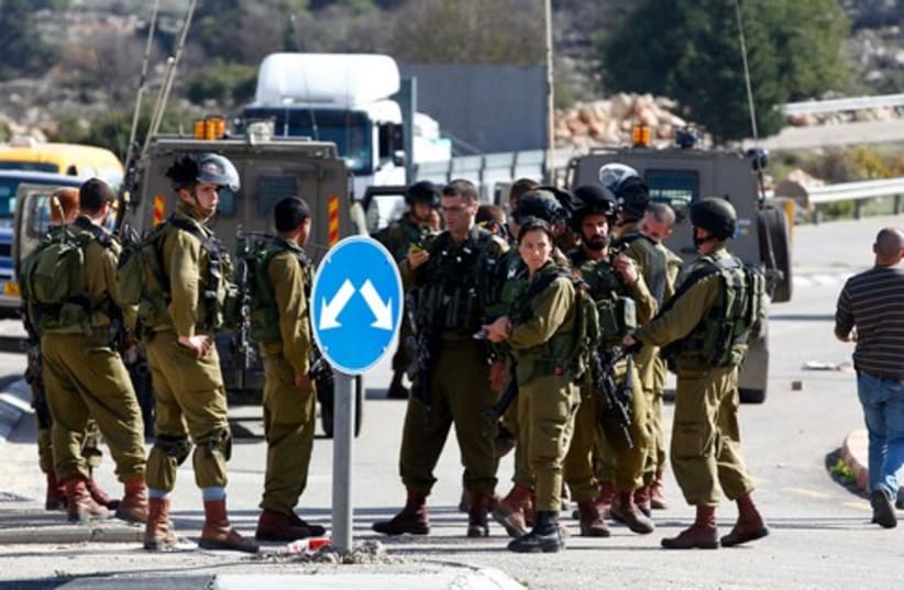 IDF soldiers at the scene of a stabbing attack in Gush Etzion, December 1, 2013. (photo credit: REUTERS)