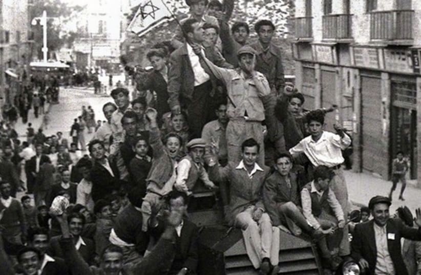 Jews crowd onto a British army armoured car as they celebrate in downtown Jerusalem the morning after the United Nations voted on November 29, 1947 to partition Palestine which paved the way for the creation of the State of Israel on May 15, 1948.  (photo credit: REUTERS)