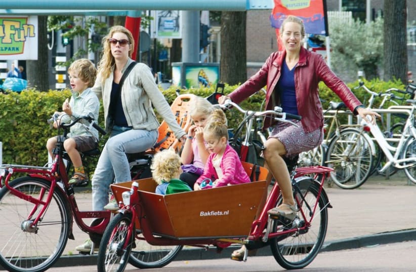Women ride bikes with their children in Utrecht. (photo credit: Courtesy)