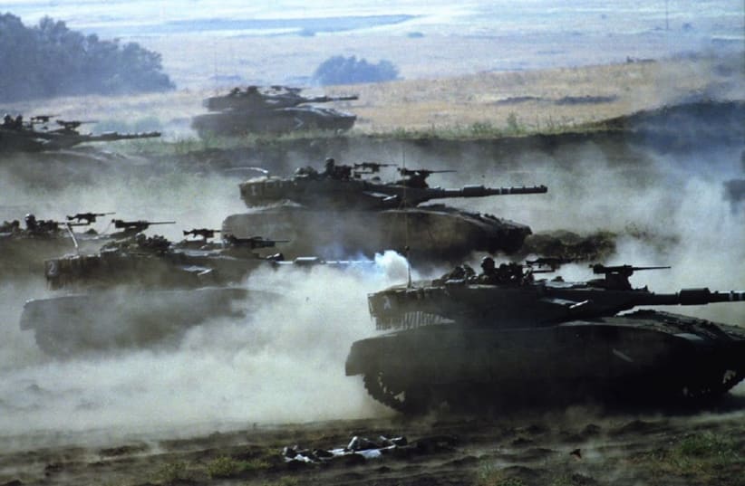 Israeli army Merkava tanks churn up dust as they race towards targets during a live-fire exercise (photo credit: REUTERS)