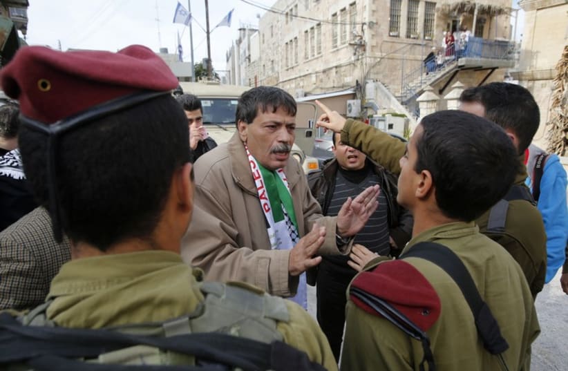 Palestinian Authority Minister Ziad Abu Ein‏ argues with IDF soldiers in Hebron, November 29, 2014 (photo credit: REUTERS)