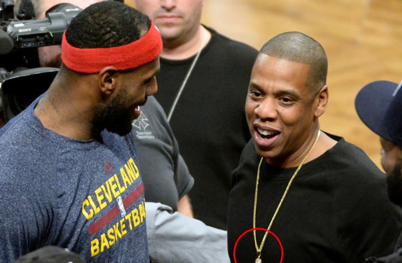 LeBron James (left) talks with Jay Z (right) during the game against the Brooklyn Nets at Barclays Center. (photo credit: REUTERS)