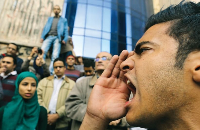 A man shouts anti-government slogans during a protest against the court dropping its case against Egypt’s former president Hosni Mubarak, in Cairo. (photo credit: REUTERS)