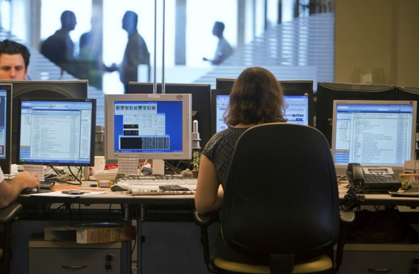 Brokers in the trading room of an investment bank in Tel Aviv (photo credit: NIR ELIAS / REUTERS)