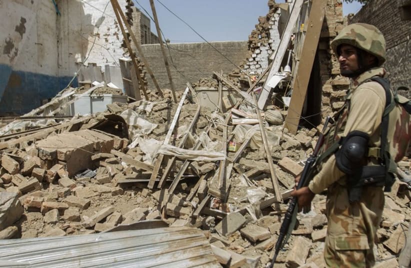 A Pakistani soldier standing near the debris of a house which was destroyed during a military operation against Taliban militants. (photo credit: REUTERS)