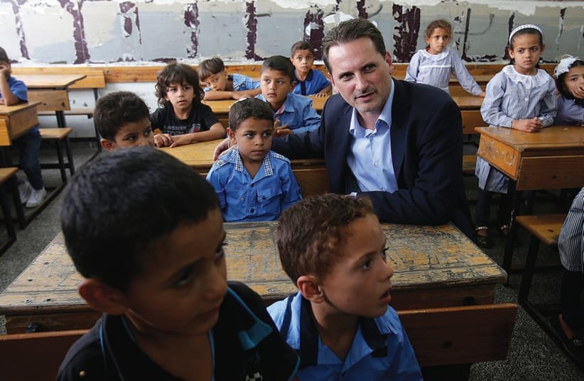 UNRWA Commissioner-General Pierre Krahenbuhl sits with students at a UN-run school in Khan Yunis in the Gaza Strip  in the Gaza Strip earlier this year (photo credit: REUTERS)