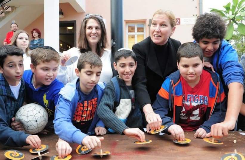 MK Tzipi Livni and a group of children at the Guinness world record dreidel challenge in Tel Aviv (photo credit: KFIR SIVAN)