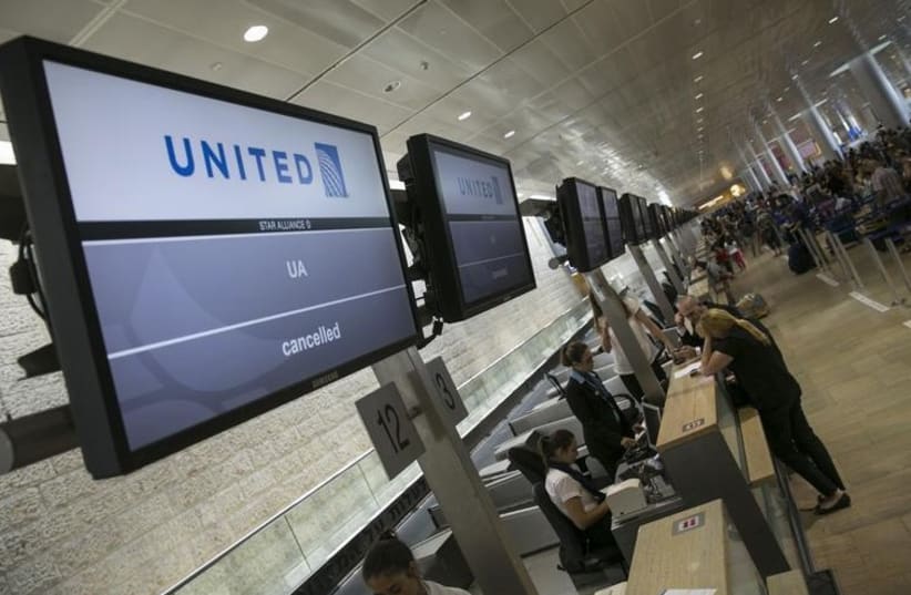 Passengers stand near a check-in desk at Ben-Gurion International Airport, near Tel Aviv (photo credit: REUTERS)