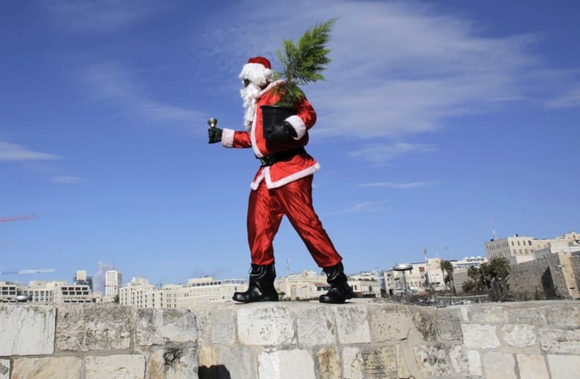 Santa distributes free Christmas trees in the Old City. (photo credit: REUTERS)