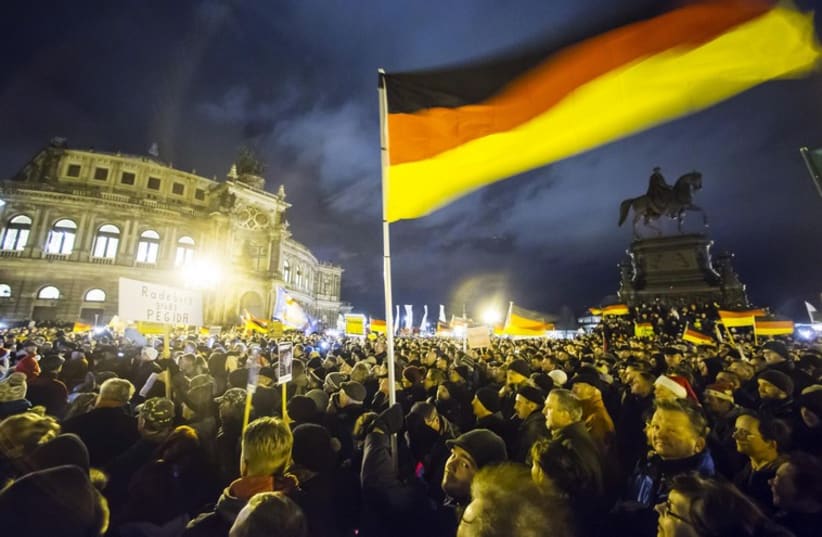 Participants hold German national flags during a demonstration organized by anti-immigration group Pediga at Dresden. (photo credit: REUTERS)