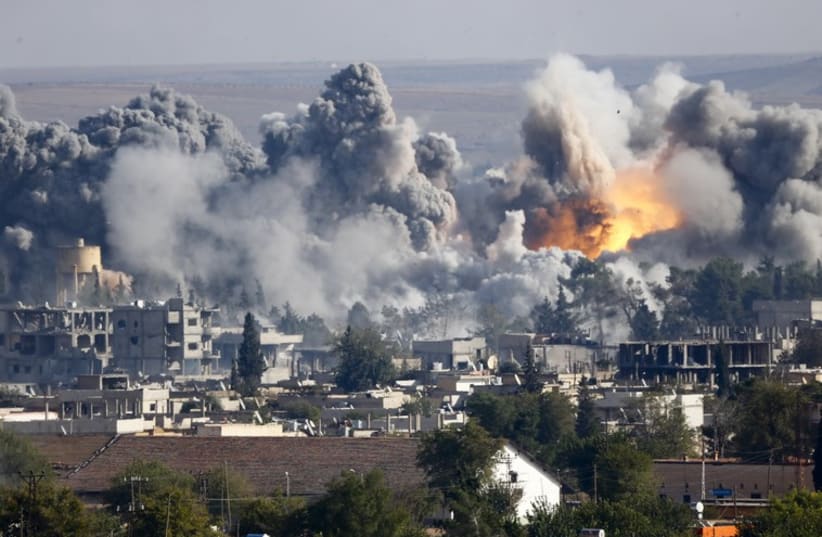 Smoke rises over Syrian town of Kobani after an airstrike (photo credit: REUTERS)