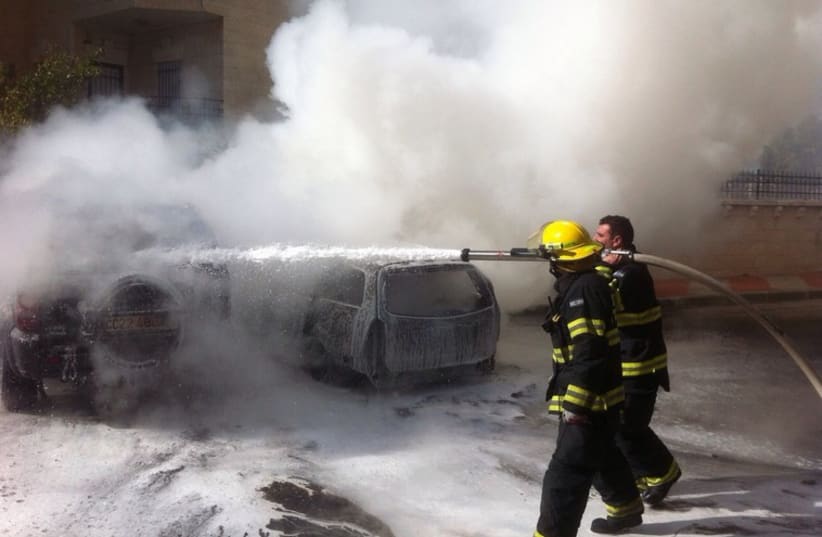 Jerusalem firefighters extinguish a car set on fire in front of the capital’s British Consulate (photo credit: JERUSALEM FIRE DEPARTMENT)