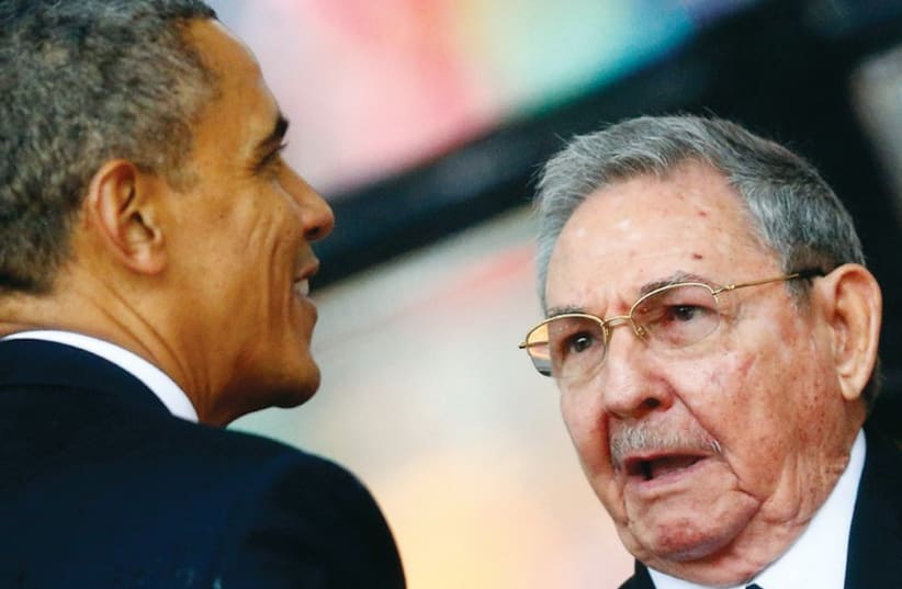 Barack Obama greets Cuban President Raul Castro at the funeral of South African president Nelson Mandela (photo credit: REUTERS)