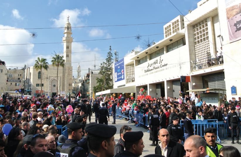 THOUSANDS OF Palestinians and foreign visitors await the arrival of the Latin Patriarch at Manger Square in Bethlehem on Christmas eve. (photo credit: SETH J. FRANTZMAN)