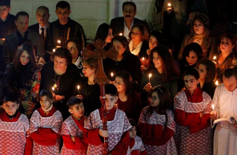 Iraqi Christians pray during a mass on Christmas eve at a church in Baghdad (photo credit: REUTERS)