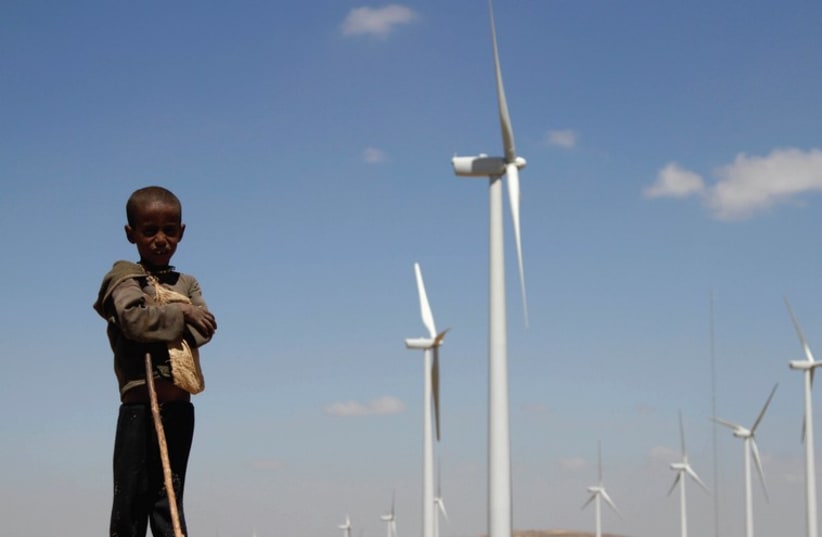 A BOY stands in front of wind turbines at the Ashegoda Wind Farm north of Addis Ababa. (photo credit: KUMERRA GEMECHU/REUTERS)