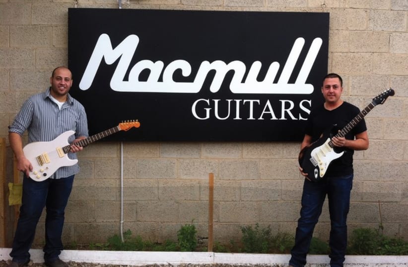 Tal (left) and Shai Macmull showcase their guitars outside the workshop (photo credit: NAAMA BARAK,MUSÉE DE LA TOUR DE DAVID,MYISRAEL)