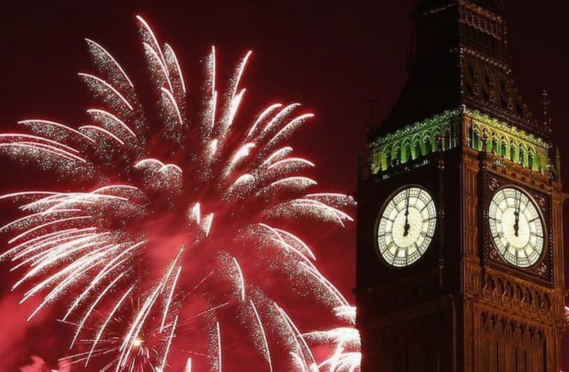 Fireworks explode behind the Houses of Parliament and Big Ben on the River Thames during New Year's celebrations in London (photo credit: REUTERS)