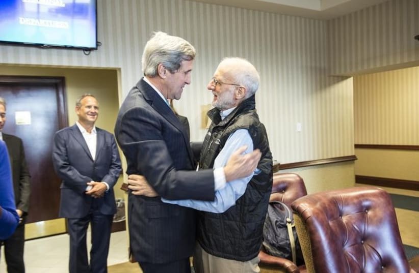 US Secretary of State John Kerry (L) embraces Alan Gross at Joint Base Andrews (photo credit: REUTERS)