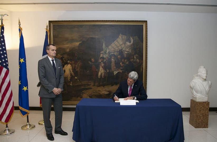 US Secretary of State John Kerry signs a book of condolences for the attack in Paris, at the French Embassy in Washington, D.C., January 9, 2015.  (photo credit: STATE DEPARTMENT PHOTO)