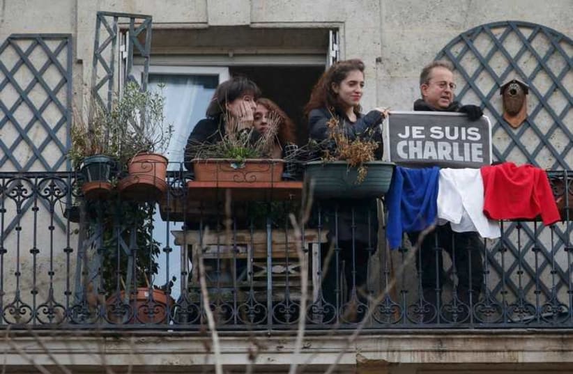 Citizens on their balcony watch solidarity march in Paris (photo credit: REUTERS)