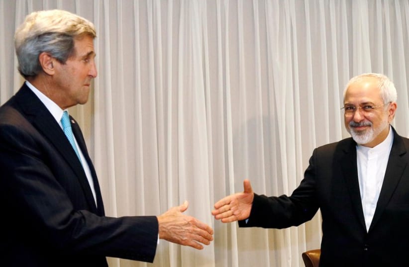US Secretary of State John Kerry shakes hands with Iranian Foreign Minister Mohammad Javad Zarif before a meeting in Geneva January 14, 2015 (photo credit: REUTERS)