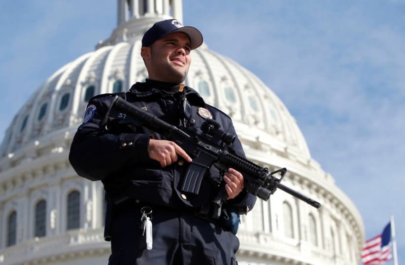 A US Capitol police officer keeps watch in front of the Capitol in Washington [File] (photo credit: REUTERS)