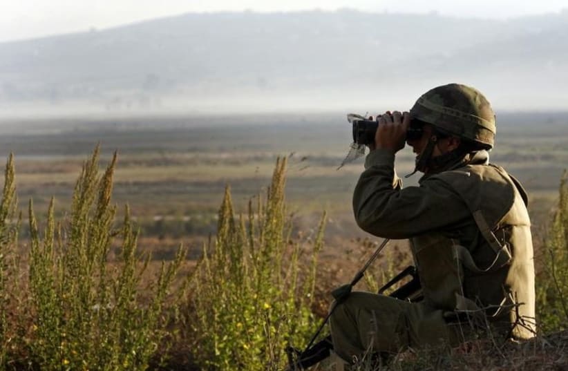 An IDF soldier looks through binoculars (photo credit: REUTERS)