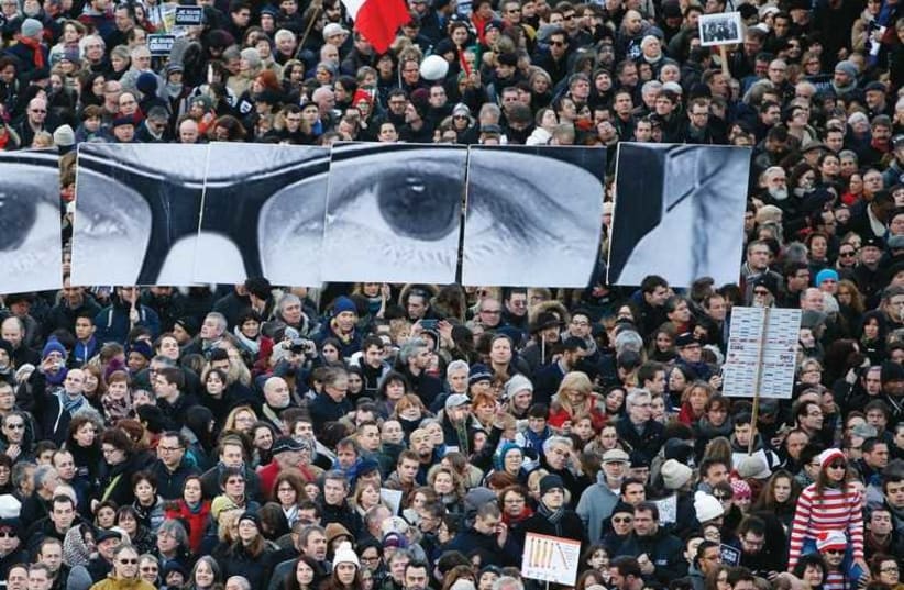 People hold panels to create the eyes of late ‘Charlie Hebdo’ editor Stephane Charbonnier. (photo credit: REUTERS)