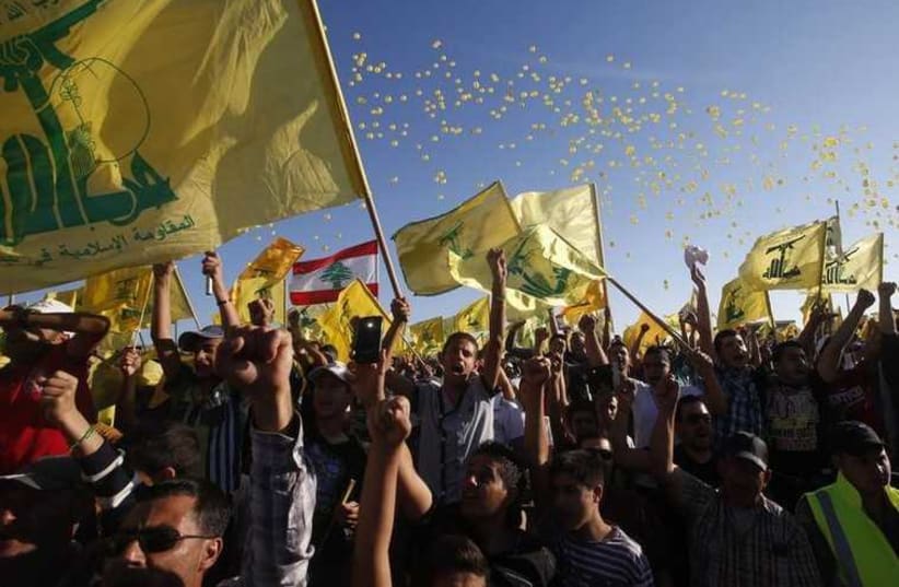 People cheer while carrying Hezbollah flags as they celebrate Resistance and Liberation Day in Bint Jbeil (photo credit: REUTERS)