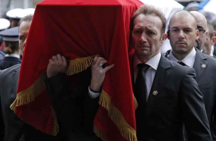 French police officers carry the flag-draped coffin of their late colleague Franck Brinsolaro at the end a national tribute at the Paris Prefecture (photo credit: REUTERS)