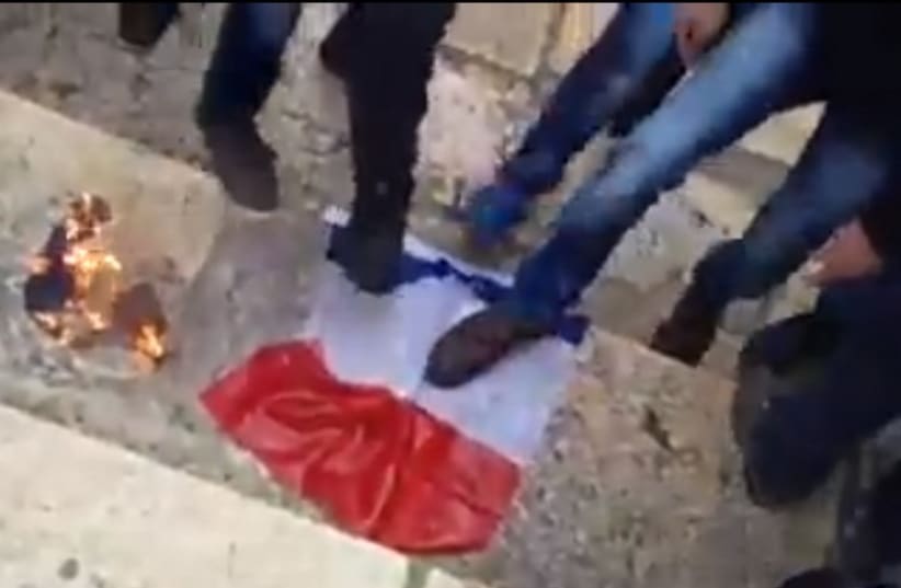 Protesters on Temple Mount burn a French Flag (photo credit: SCREEN CAPTURE: SHEHAB NEWS AGENCY/FACEBOOK)