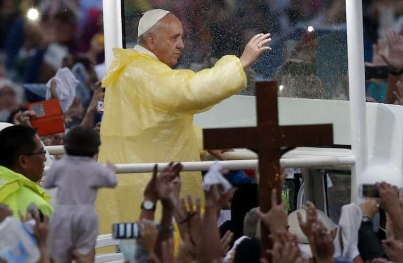 Pope Francis waves from the popemobile after leading a Mass at Rizal Park in Manila (photo credit: REUTERS)