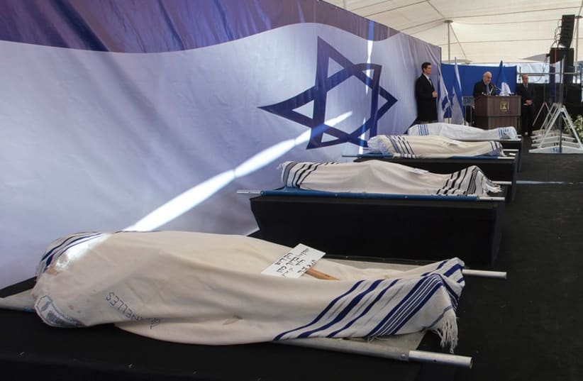 PRESIDENT REUVEN Rivlin delivers a speech near the covered bodies of Yohan Cohen, Yoav Hattab, Philippe Braham and Francois-Michel Saada, victims of Friday’s attack on a Paris grocery, during their joint funeral in Jerusalem. (photo credit: REUTERS)