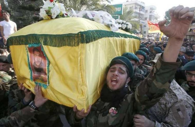 Hezbollah members react while carrying the coffin of Abbas Hijazi, who died in an airstrike in Quneitra (photo credit: REUTERS)