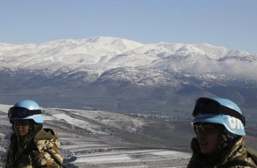 UN peacekeepers of the United Nations Interim Force in Lebanon stand in front of snow-covered mountains in Kfar Kila village near the Lebanese-Israeli border (photo credit: REUTERS)