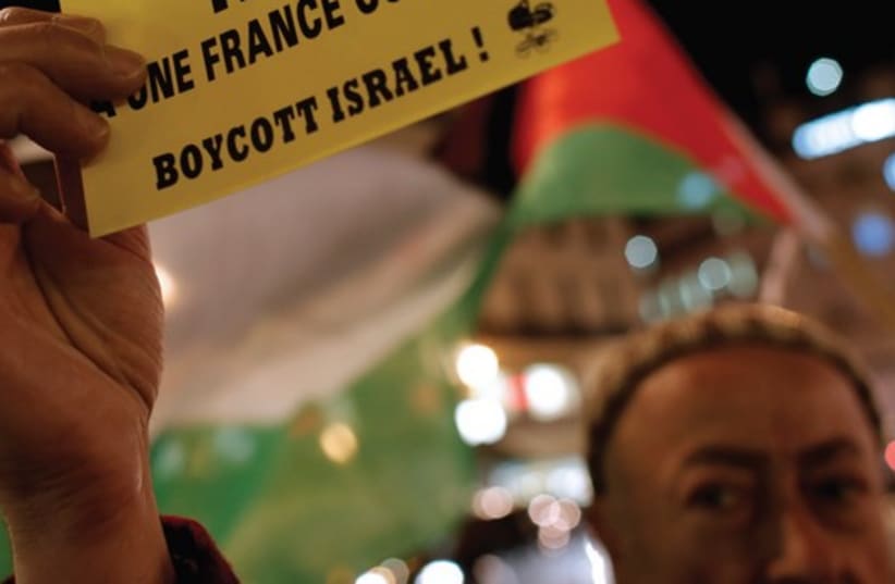 A PALESTINIAN supporter holds a protest leaflet advocating a boycott of Israel in France (photo credit: REUTERS)
