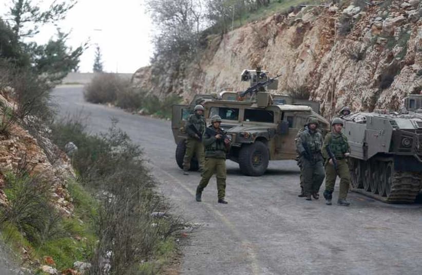 Israeli soldiers walk near military vehicles near Israel's border with Lebanon January 28, 2015. (photo credit: REUTERS)