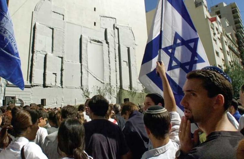 MEMBERS OF the Argentine Jewish community congregate in front of the outline of the former Israeli embassy in Buenos Aires to commemorate the eighth anniversary of the building’s destruction by a car bomb (photo credit: REUTERS)
