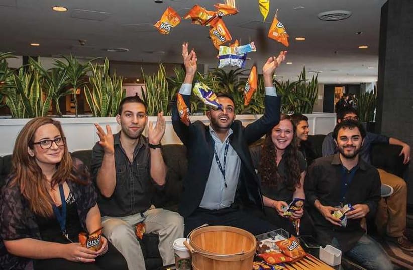 STUDENTS AT the Israeli-American Council’s Mishelanu National Conference in Los Angeles enjoy Israeli snacks Bamba and Bisli on Saturday (photo credit: RANI SIKOLSKY/IAC)