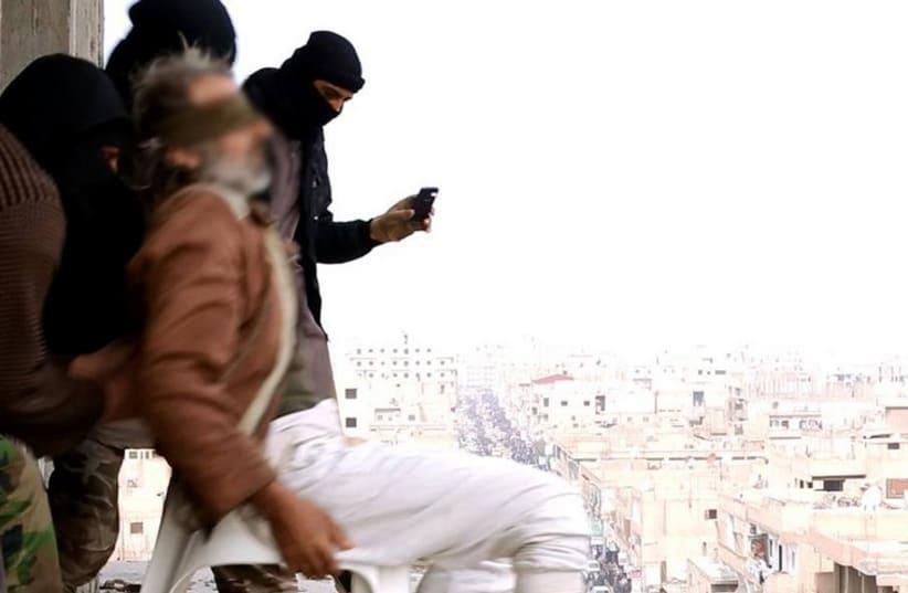 Masked Islamic State terrorists throw man accused of being gay off of a high-rise building (photo credit: Courtesy)