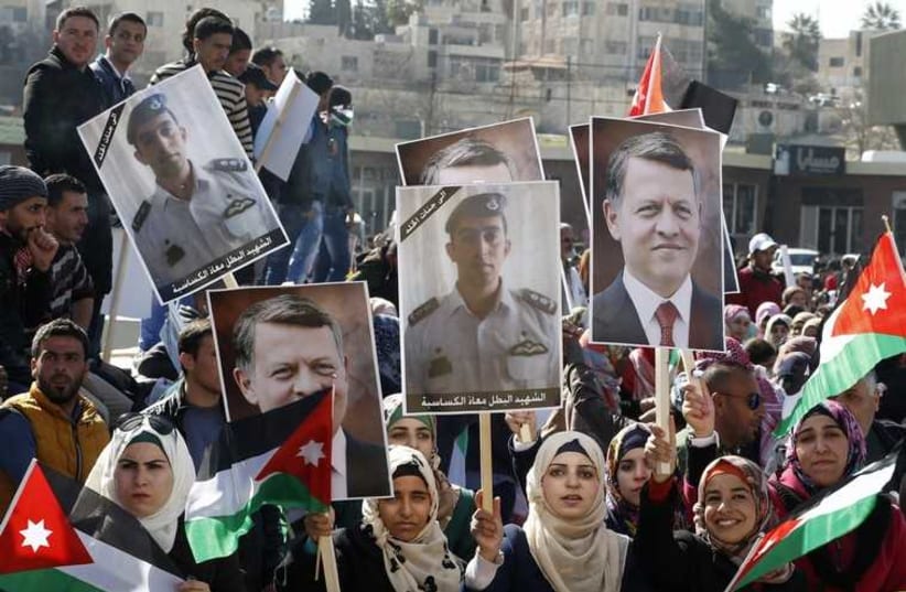Jordanian protesters hold up pictures of Jordanian King Abdullah and Jordanian pilot Muath al-Kasaesbeh, as they chant slogans during a rally in Amman to show their loyalty to the King and against the Islamic State, February 5, 2015. (photo credit: REUTERS)