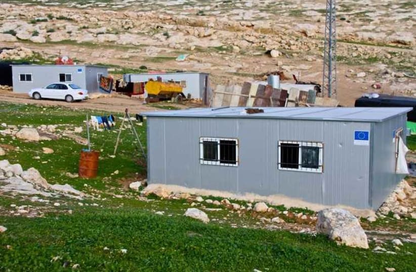 The blue EU logo seen on new modular structures in an illegal Beduin encampment in the Judean hills outside the Ma'alen Adumim settlement.  (photo credit: TOVAH LAZAROFF)
