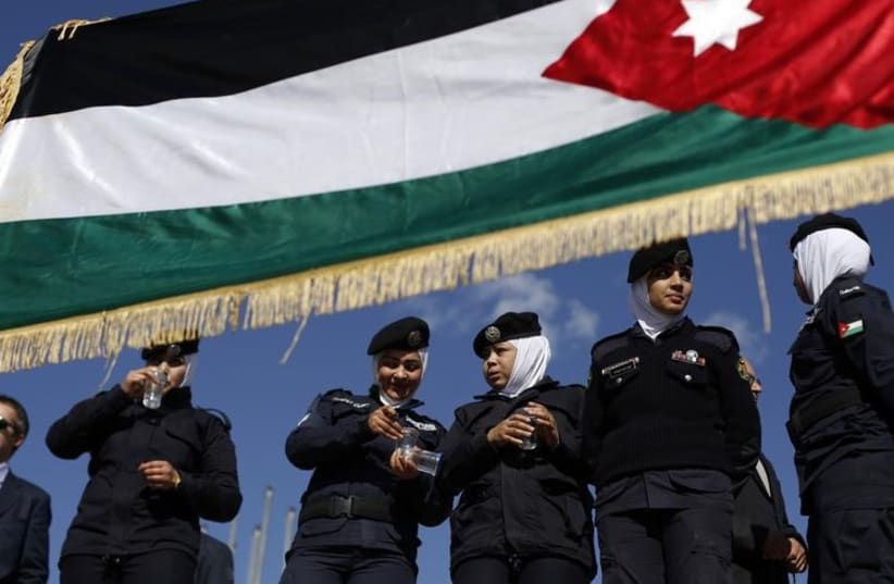 Jordanian police women stand guard near a Jordanian national flag during a rally in loyalty to the King and against the Islamic State (photo credit: REUTERS)