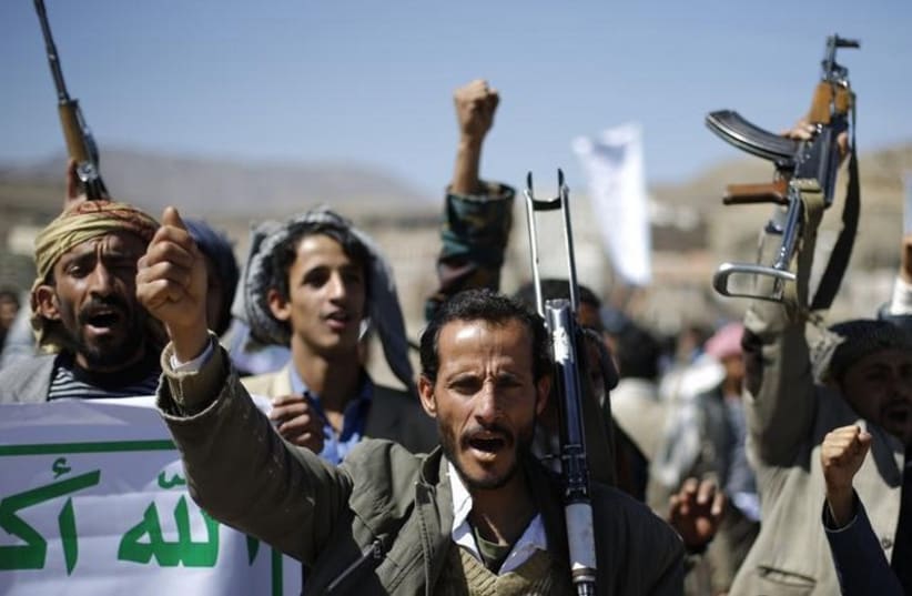Followers of the Houthi movement shout slogans during a gathering to show support to the movement outside the Presidential Palace in Sanaa (photo credit: REUTERS)