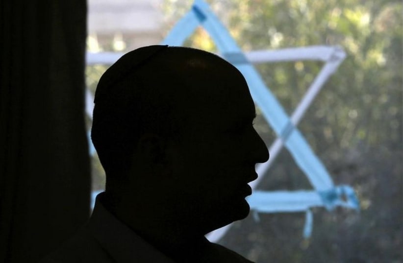 Naftali Bennett, head of the Bayit Yehudi party, is silhouetted as he talks to students at a pre-army training course as he campaigns in the Shapira Center near the southern city of Ashkelon (photo credit: REUTERS)