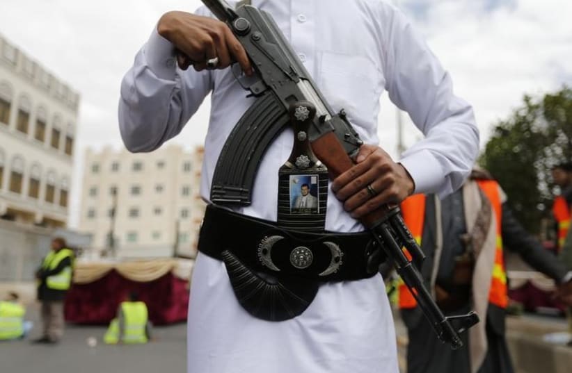 A Shi'ite Houthi militant poses for a photo during a mass funeral for victims of a suicide attack on followers of the Shi'ite Houthi group in Sanaa (photo credit: REUTERS)